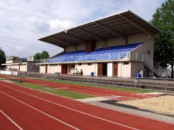 Die gedeckte Zuschauertribüne mit den blauen Stühlen.