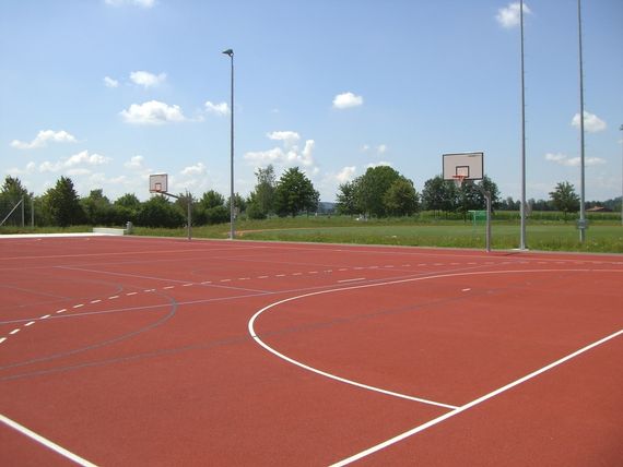 Der rote Basketballplatz hinter der Sporthalle.