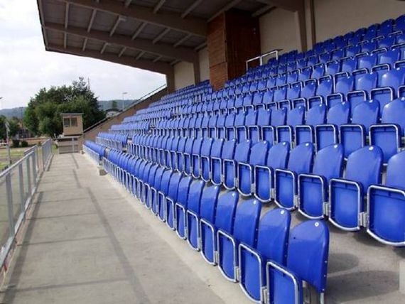 Die hochgeklappten blauen Stühle auf der Zuschauertribüne