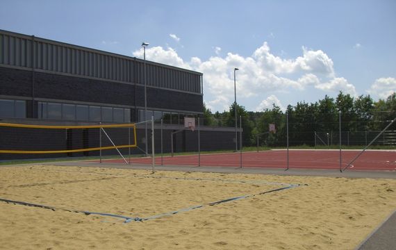 Das Beachvolleyball Feld neben dem roten Basketballplatz.