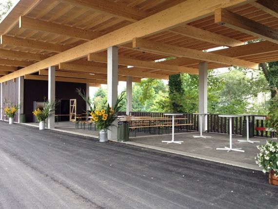 Der Unterstand beim Pavillon Murg-Auen-Park mit Tischbankgarnituren, Stehtischen und Blumendeko.