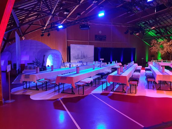 Im Winterthema dekorierte Festhalle mit aufgestellten Tischbankgarnituren und einem Iglu.