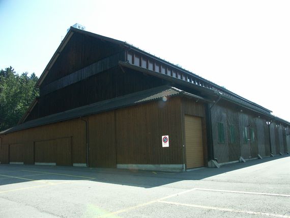Die Festhalle von der Rückseite mit dem Holzvorbau als Lager und Rückseite der Bühne.