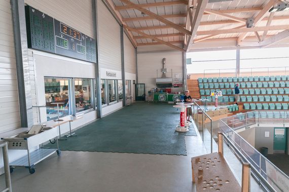 Die Tribüne der Kunsteisbahn Frauenfeld mit den grünen Stühlen.