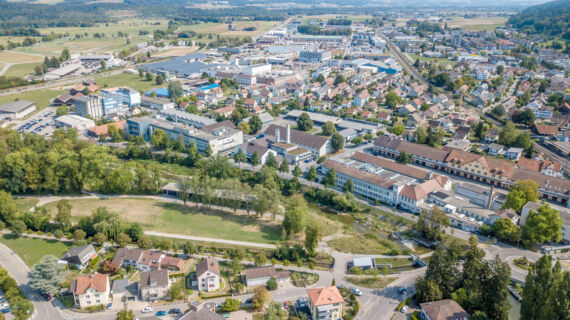 Eine Luftaufnahme mit der Stadt Frauenfeld im Hintergrund und der Murg-Auen-Park mit der grossen Wiese.
