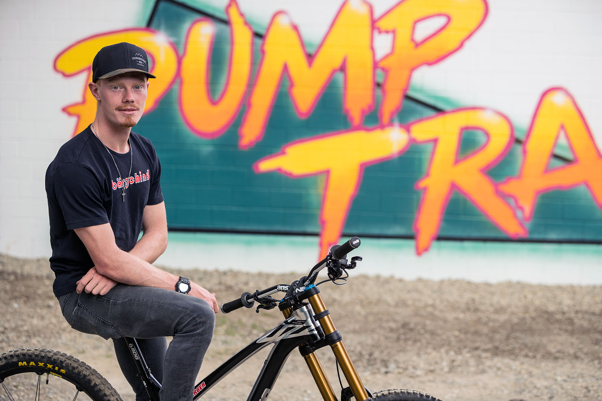 Eine Person auf einem BMX-Velo vor einem gelben Grafiti.